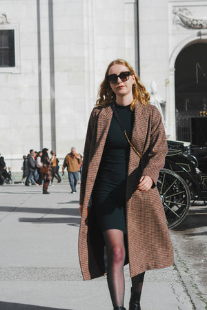 Woman in a long coat walking down the street
