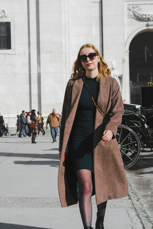 Woman in a long coat walking down the street
